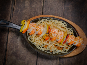 Espetinho de camarões com cebola e pimentões assados na brasa com espaguete ao alho crocante do Tango Casa de La Parrilla